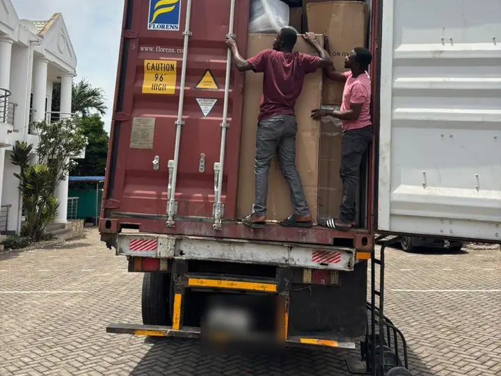 A team unloading cartons from a container