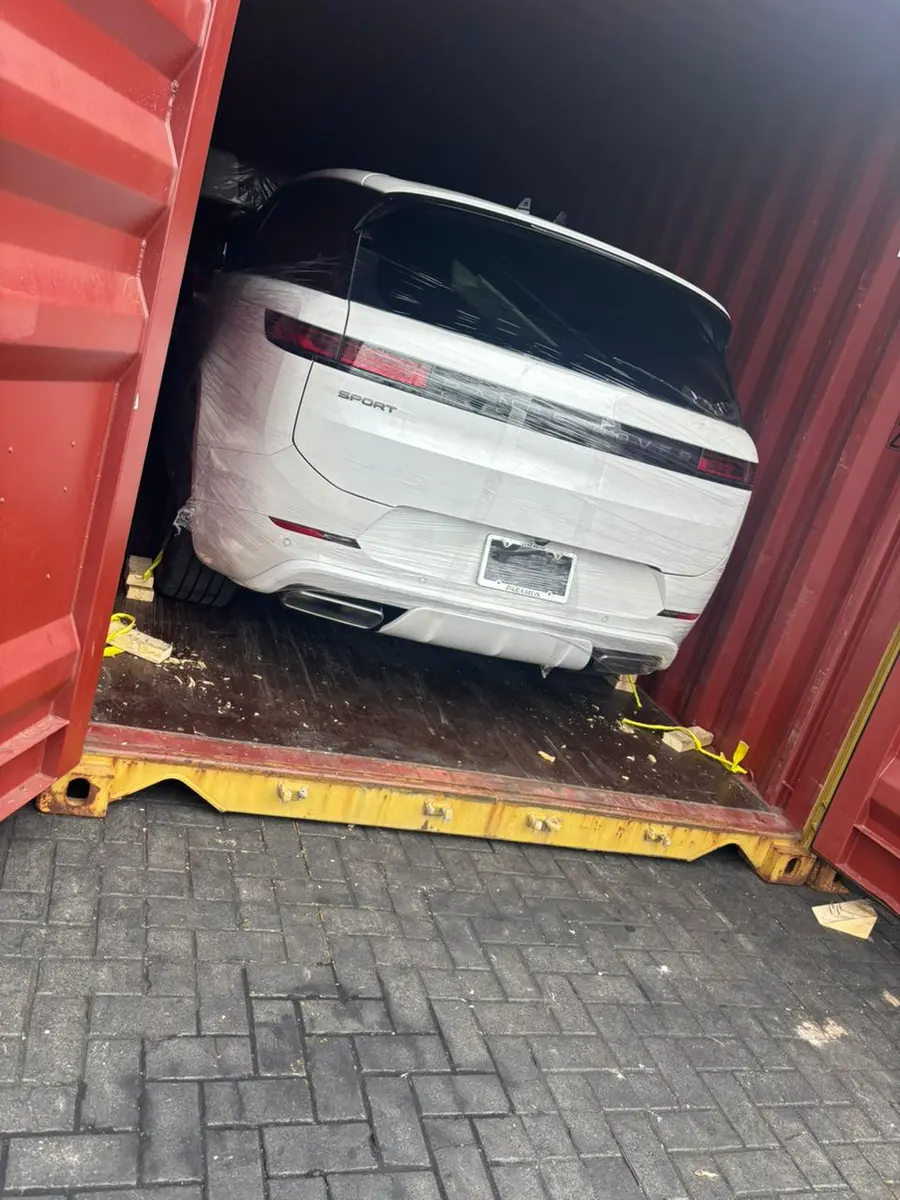 A white Range Rover secured inside a shipping container
